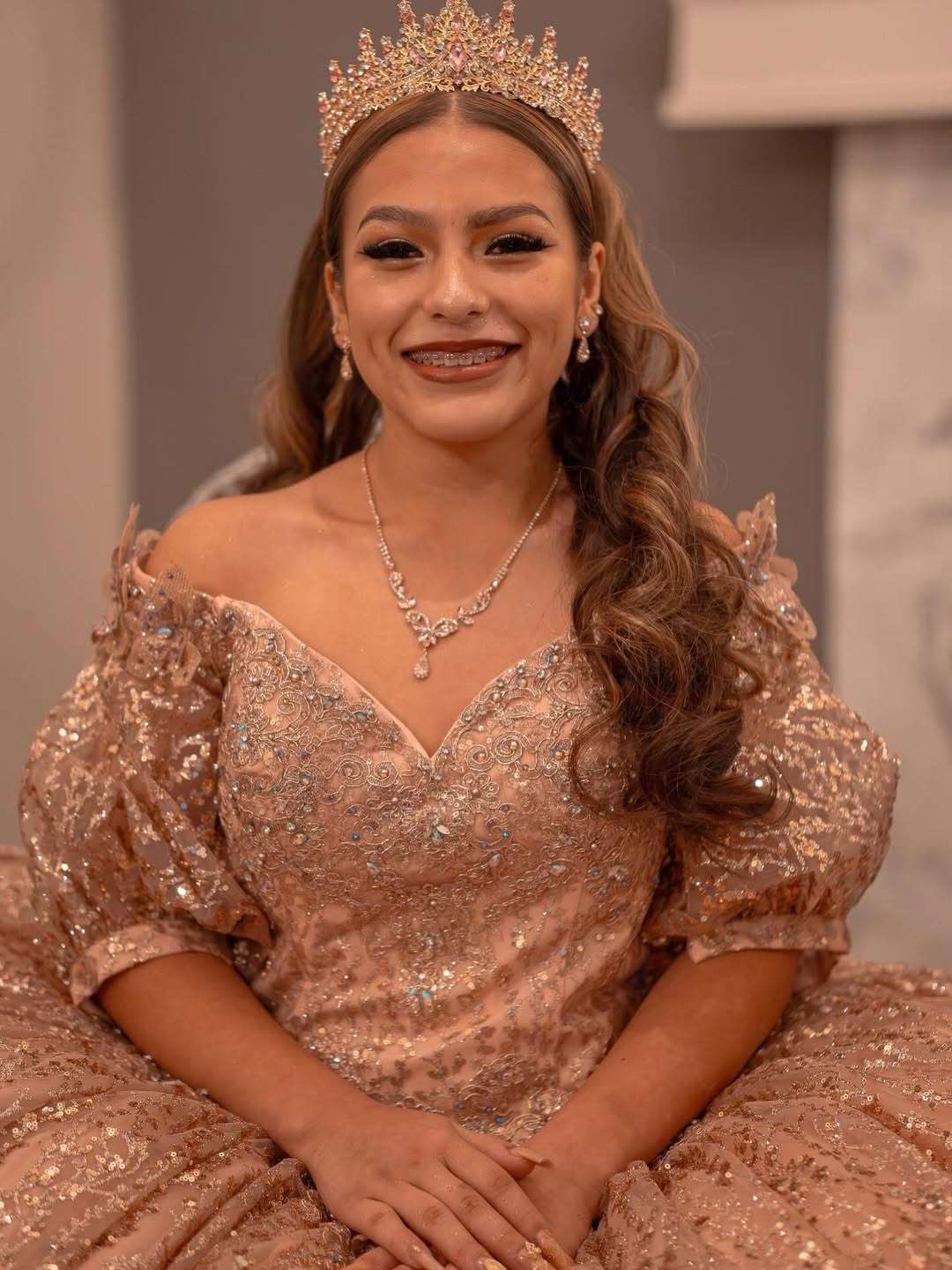 Quinceañera in rose-gold sequin gown with crystal crown and full glam by MakeupByGen